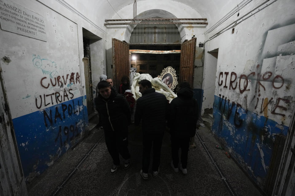 Artisans carry a "Mistero", a float depicting a biblical scene, out of the former prison of Procida Island, Italy, early Friday, March 29, 2024. Italy is known for the religious processions that take over towns big and small when Catholic feast days are celebrated throughout the year. But even in a country where public displays of popular piety are a centuries-old tradition, Procida's Holy Week commemorations stand out. (AP Photo/Alessandra Tarantino)