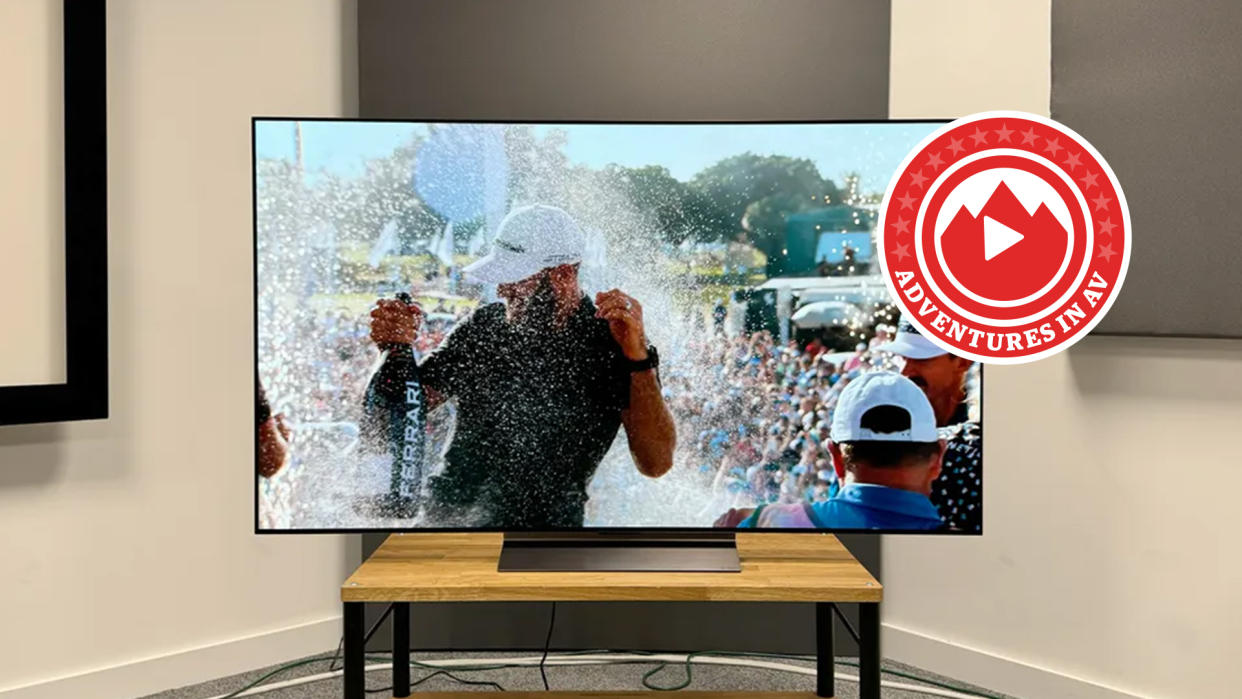  65-inch LG C4 TV on a wooden stand. A golfer is being sprayed with champagne on the screen. 