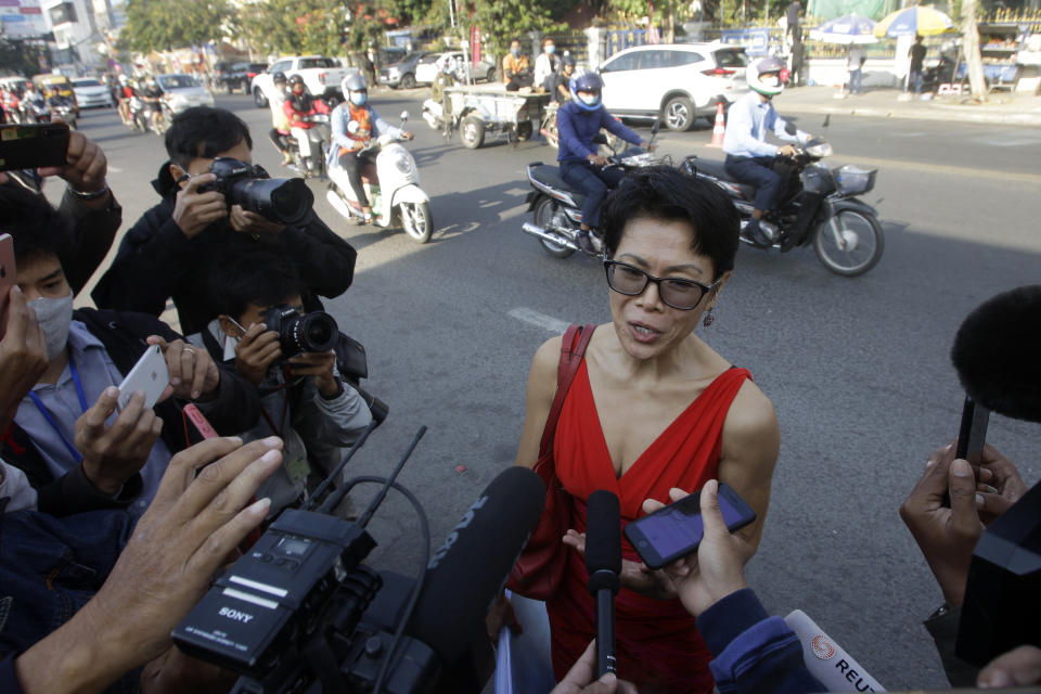 Theary Seng, center, a Cambodian-American lawyer, talks with journalists as she arrives in front of Phnom Penh Municipal Court in Phnom Penh, Cambodia, Thursday, Jan. 14, 2021. Theary Seng said Thursday she was being persecuted for her political opinion as she and dozens of other government critics charged with treason and other offenses returned to court in a trial criticized by rights advocates. (AP Photo/Heng Sinith)