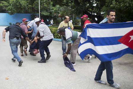 Cuban security personnel detain a supporter of the Ladies in White dissident group (L), during a protest on International Human Rights Day, Havana, December 10, 2015. REUTERS/Alexandre Meneghini