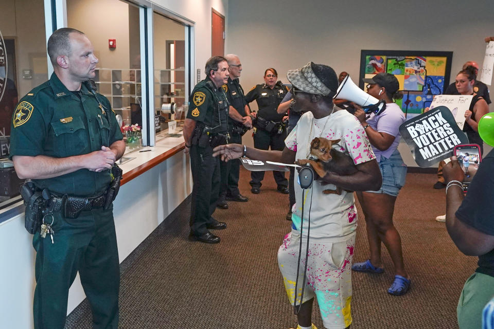 Protesters confront Marion County sheriff deputy's at the Marion County Courthouse, Tuesday, June 6, 2023, in Ocala, Fla. Authorities came under intense pressure to bring charges against a white woman who killed Ajike Owens, a 35-year-old mother of four, a Black neighbor, on her front doorstep, as they navigated Florida’s divisive stand your ground law that provides considerable leeway to the suspect in making a claim of self defense. (AP Photo/John Raoux)