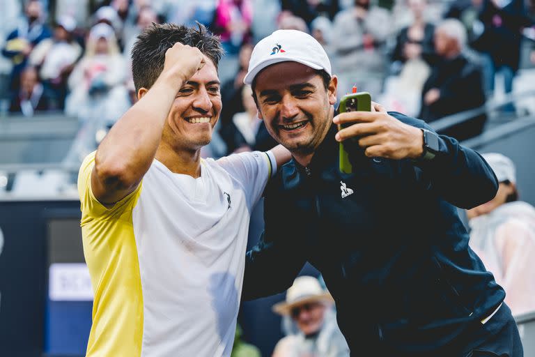 Sebastián Báez celebra con uno de sus entrenadores en comunicación con su coach principal, Sebastián Gutiérrez