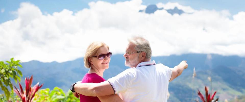 Senior couple hiking in mountains. Mature man and woman trekking in Borneo jungle. Family looking at Mount Kinabalu peak, highest mountain of Malaysia. Summer vacation in Southeast Asia.