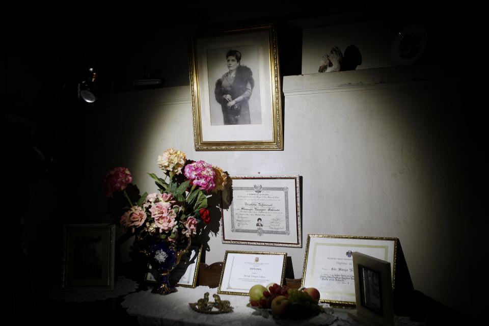 In this Nov. 26, 2012 photo, a 1940's portrait of journalist and radio host Maria Julia Venegas, university titles and certificates are on display at her home in Lima, Peru. Venegas who began broadcasting “Radio Club Infantil,” a show for Peru's children in the golden age of radio and World War II, has earned a citation from Guinness World Records as the globe's longest-running radio personality. (AP Photo/Karel Navarro)