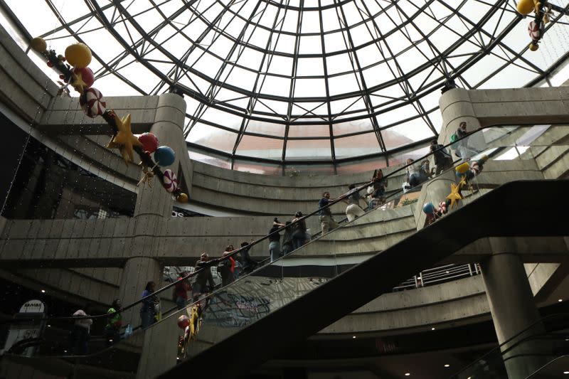 People stand on escalators at a mall during the Black Friday sales in Caracas