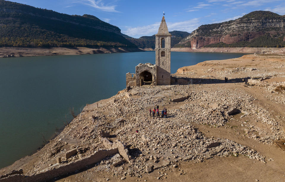 FILE - A church and remains of an ancient village which are usually covered by water are seen inside the reservoir of Sau, in Vilanova de Sau, Catalonia, Spain, on Nov. 23, 2022. Spain has officially entered a period of a long-term drought owing to high temperatures and low rainfall over the past three years and likely faces another year of heatwaves and forest fires, the country’s weather agency Aemet said Friday March 17, 2023. (AP Photo/Emilio Morenatti, File)