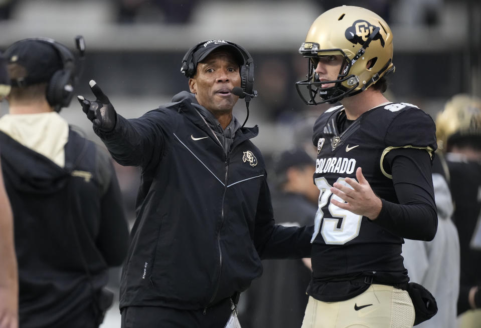 FILE - Colorado head coach Karl Dorrell, left, confers with punter Josh Watts in the second half of an NCAA college football game against Washington, Nov. 20, 2021, in Boulder, Colo. Colorado is struggling with a loss of players and a shakeup in the ranks of assistant coaches in the offseason. (AP Photo/David Zalubowski, File)