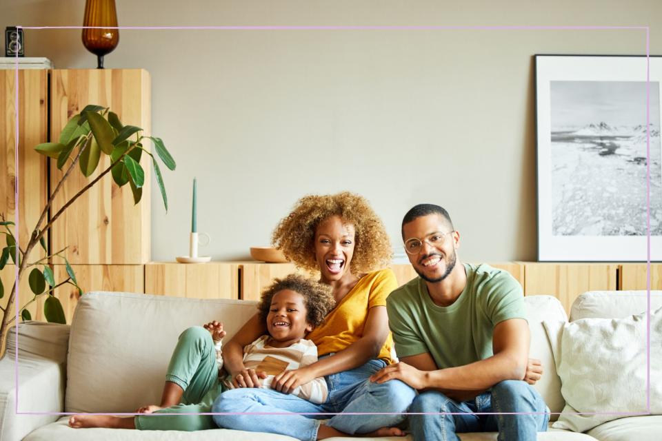 Parents and young child smiling on the sofa