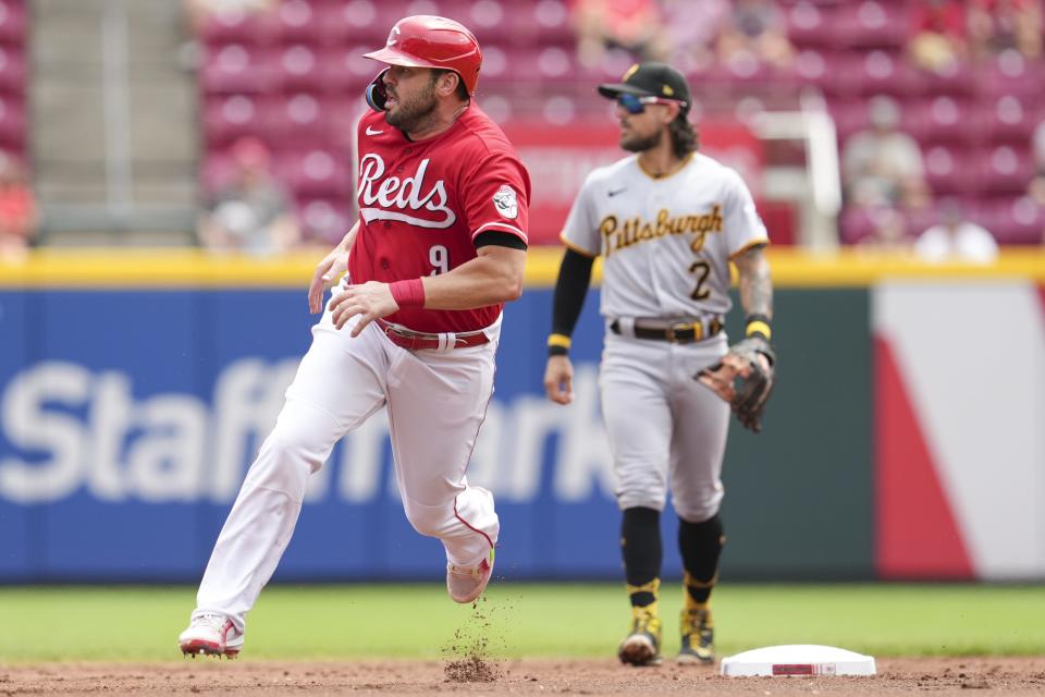 Cincinnati Reds' Mike Moustakas (9) advances to third base on a single hit by Donovan Solano during the second inning of a baseball game against the Pittsburgh Pirates Thursday, July 7, 2022, in Cincinnati.