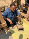 This Sept. 2020 photo provided by the Ministry of Tourism and Antiquities shows Mostafa Waziri, secretary general of the Supreme Council of Antiquities, displaying an artifact found along with more than two dozen ancient coffins unearthed near the famed Step Pyramid of Djoser in Saqqara, south of Cairo, Egypt. (Ministry of Tourism and Antiquities via AP)