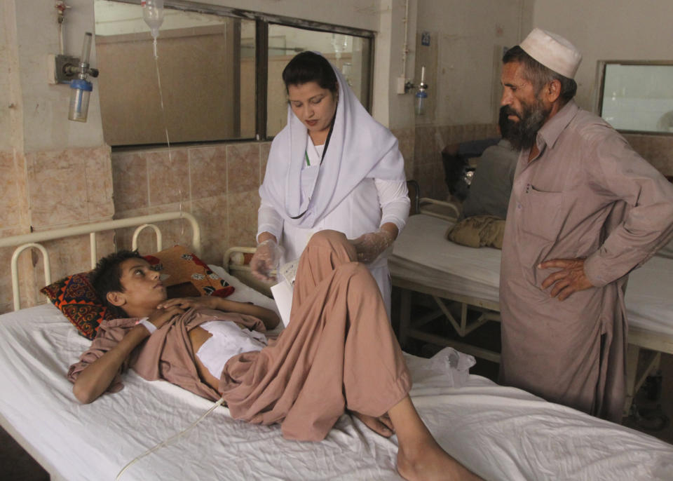 A nurse tends to a boy who survived a bombing, at a hospital in Quetta, Pakistan, Thursday, July 26, 2018. The suicide attack outside the polling station in Quetta on Wednesday, which killed dozens of people, underscored the difficulties the majority Muslim nation faces on its wobbly journey toward sustained democracy. (AP Photo/Arshad Butt)