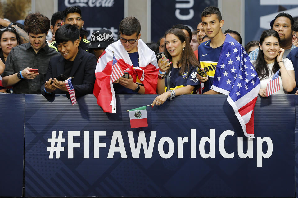 Un grupo de aficionados espera en la 6ta Avenida de Nueva York a que se anuncien las ciudades sedes del Mundial de 2026, el jueves 16 de junio de 2022 (AP Foto/Noah K. Murray)