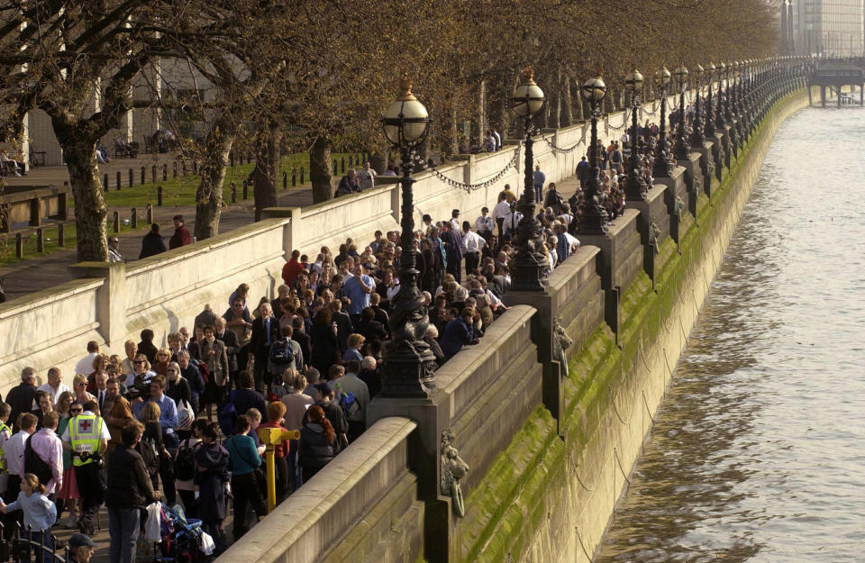 LONDON, UNITED KINGDOM:  Mourners queue-up on the over bank of the river Thames to get to Westminster Hall where the Queen mother's coffin lies in-state in London 05 april 2002. Westminster Hall will remain open to the public. AFP PHOTO NICOLAS ASFOURI (Photo credit should read NICOLAS ASFOURI/AFP via Getty Images)