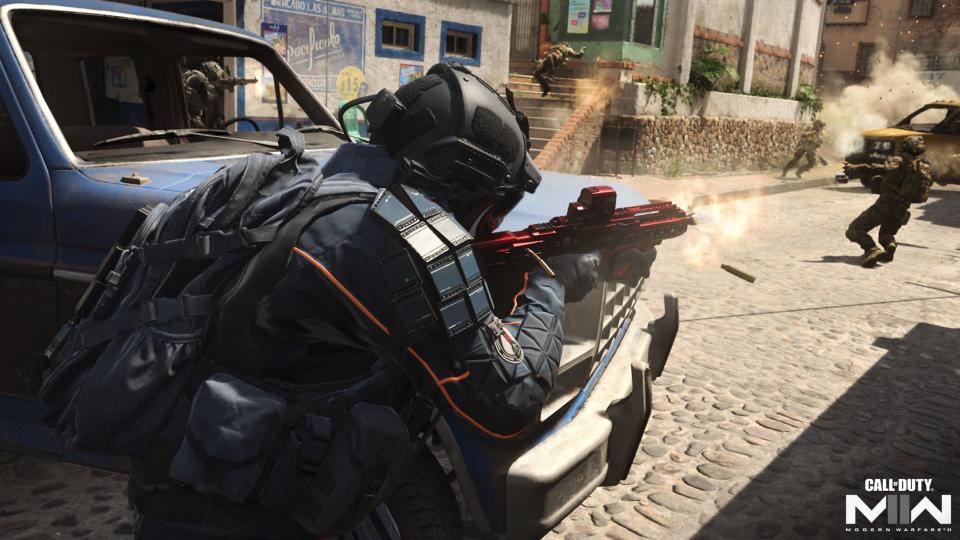 A soldier returns fire while using a car as cover