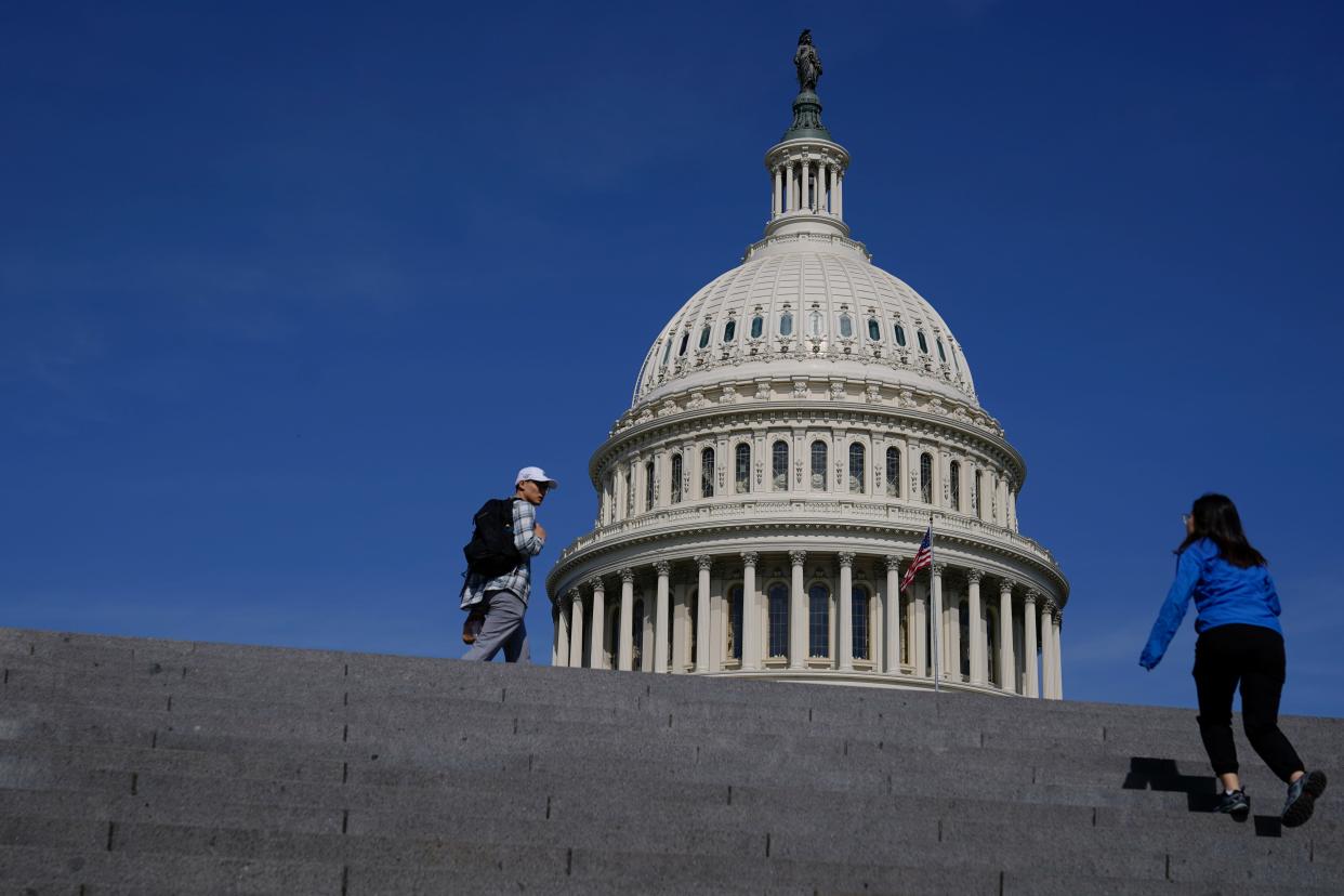 Visitors walk outside the U.S. Capitol building in Washington, Saturday, May 27, 2023.