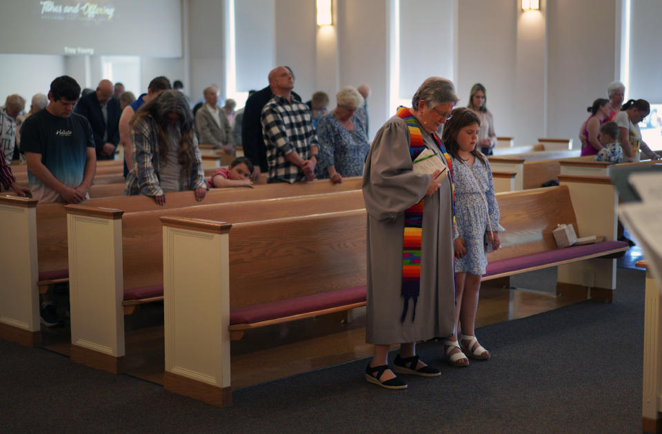 The Rev. Linda Barnes Popham, front left, prays with her congregation at Fern Creek Baptist Church, Sunday, May 21, 2023, in Louisville, Ky. In February, Fern Creek was one of five churches disfellowshipped from the Southern Baptist Convention because they have female pastors. But Fern Creek and Saddleback Church of California have decided to appeal. The challenge will be voted on at the upcoming SBC annual meeting. (AP Photo/Jessie Wardarski)