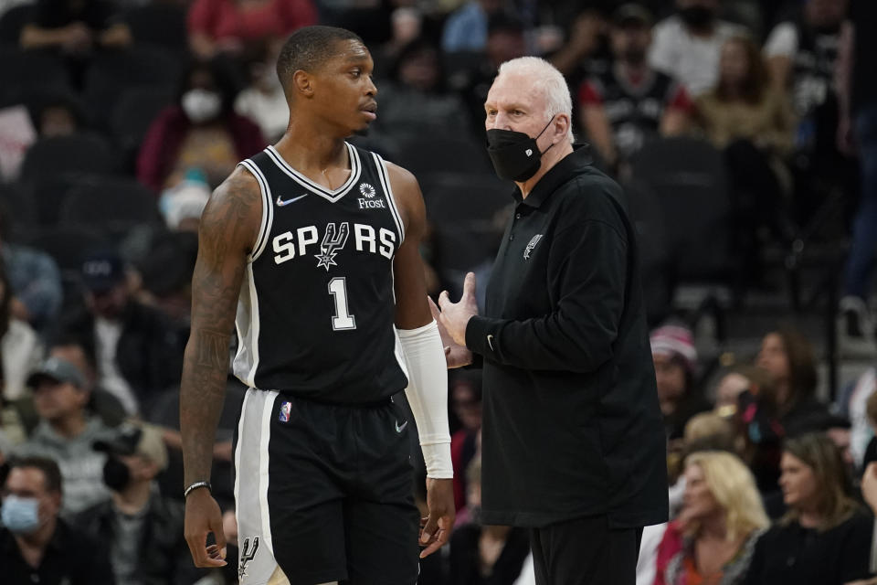 San Antonio Spurs head coach Gregg Popovich, right, talks with guard Lonnie Walker IV (1) during the first half of an NBA basketball game, Wednesday, Jan. 19, 2022, in San Antonio. (AP Photo/Eric Gay)