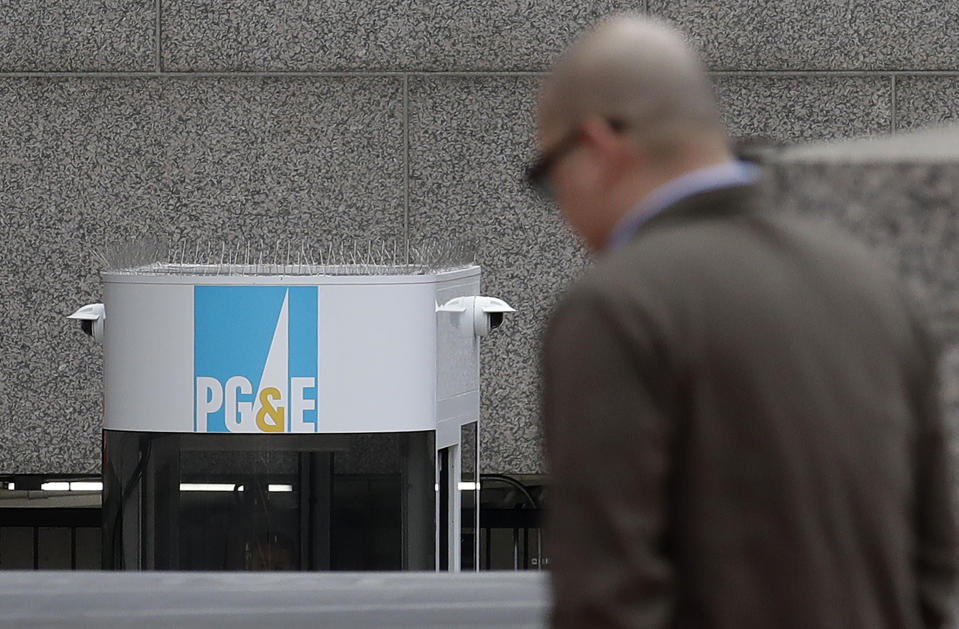 File - In this Jan. 29, 2019, file photo, a man crosses the street in front of a Pacific Gas and Electric building in San Francisco. An effort to block Pacific Gas and Electric's path out of bankruptcy kicked off the trial Wednesday, May 27, 2020, on the plan in bankruptcy court as critics of the utility questioned whether the overwhelming vote in favor of the plan by wildfire victims was tainted by conflicts of interest and shoddy counting. PG&E's plan won support last week in a landslide, with victims overwhelmingly backing PG&E's $58 billion proposal to emerge from bankruptcy after 18 months. (AP Photo/Jeff Chiu, File)