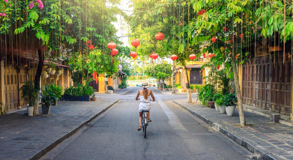 A woman bike riding on a quiet street.