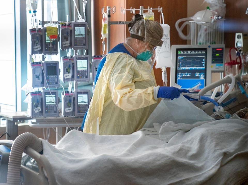 Dee Tait, a registered nurse in the intensive care unit at St. Joseph Mercy Oakland Hospital in Pontiac, tends to an intubated COVID-19 patient on Monday, Jan. 24, 2022.