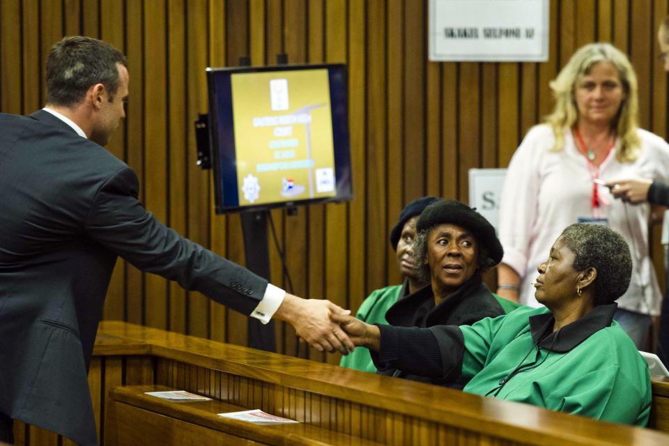 Olympic and Paralympic track star Oscar Pistorius greets members of the African National Congress Women's League during the fifth day of his trial for the murder of his girlfriend Reeva Steenkamp at the North Gauteng High Court in Pretoria, March 7, 2014. REUTERS/Theana Breugem/Pool (SOUTH AFRICA - Tags: SPORT ATHLETICS CRIME LAW POLITICS)