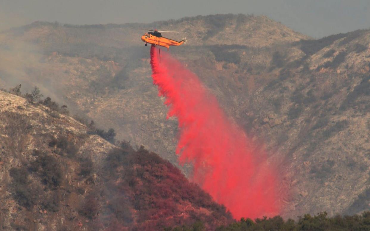 A Sikorsky S-61 makes a drops fire retardant onto a hillside. - Santa Barbara County Fire Department