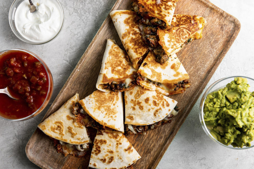 This image shows a recipe for cheesy ground beef quesadillas. More people are cooking at home these days, and when they do eat restaurant food, they’re often looking for comfort food, experts say. Other trends include simpler recipes, recipes with fewer ingredients, one-pot meals, sheet-pan meals, finger food and pantry-ingredient recipes, all up significantly year over year. (Cheyenne M. Cohen/Katie Workman via AP)