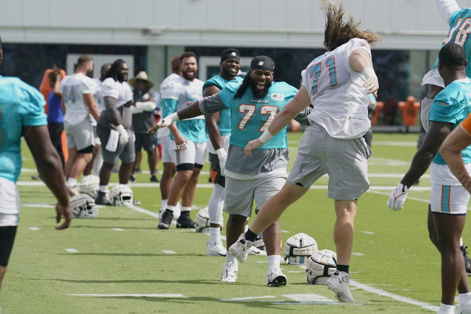 Miami Dolphins offensive lineman Blaise Andries (71) cheers with defensive tackle John Jenkins (77) at the start of drills at the NFL football team's practice facility, Saturday, July 30, 2022, in Miami Gardens, Fla. (AP Photo/Marta Lavandier)