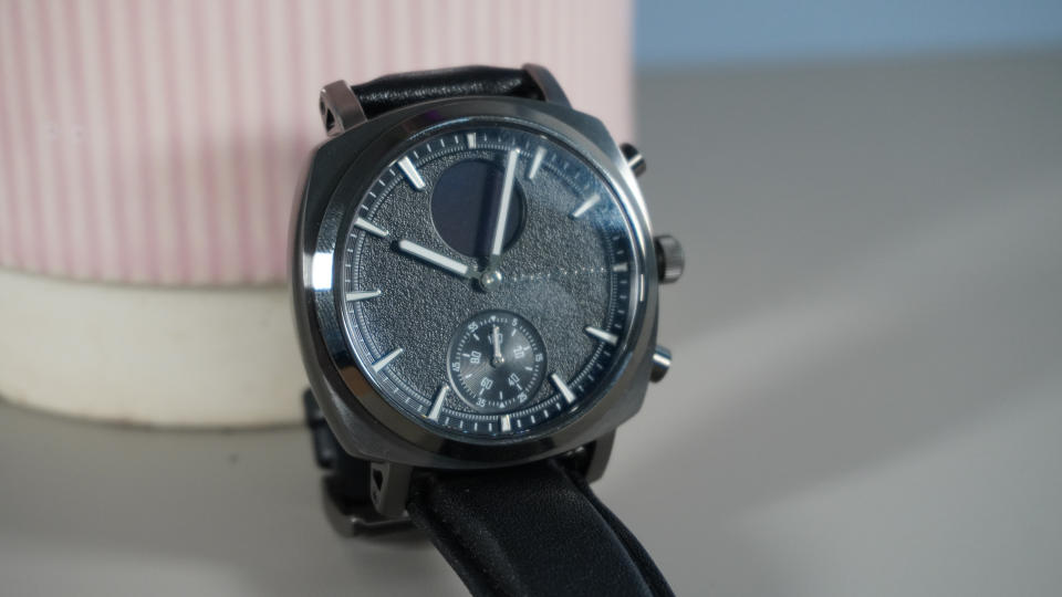 The Pininfarina Senso Hybrid smartwatch on a grey background against a pink plant pot