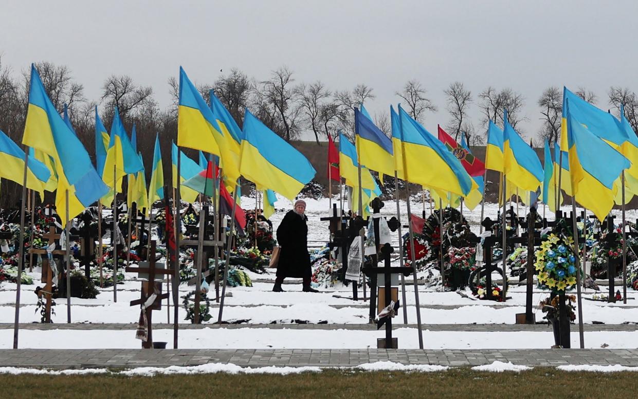 A woman walks among the graves at the Alley of Heroes, where Ukrainian soldiers killed in the war are buried, in Kramatorsk, Donetsk