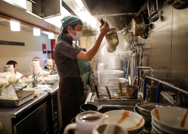 Sixty-year-old Yashiro Haga cooks ramen noodles at his noodle shop 'Shirohachi', amid the coronavirus disease (COVID-19) outbreak, in Tokyo