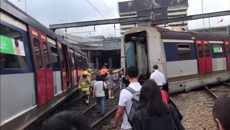 People and emergency crew are seen at a derailed train wreckage near Hung Hom station on the MTR East Rail Line following an accident on a train bound for Mong Kok East in Hong Kong