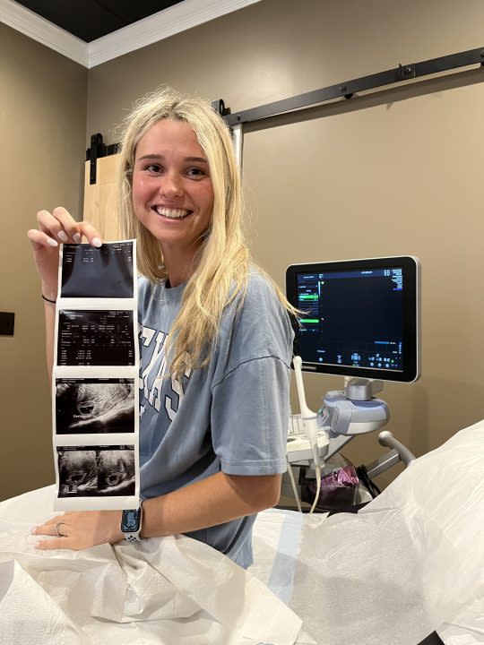 Savannah holding ultrasound photos.