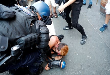 A demonstrator is detained after a protest march during the G7 summit, in Hendaye