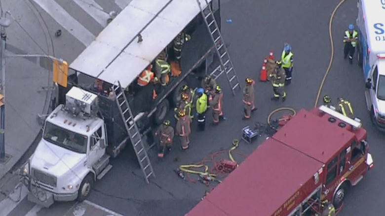 Firefighters and paramedics free injured worker from hot tar truck in Toronto