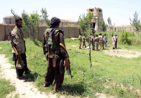 Afghan militias and policemen gather as they discuss during a battle at the Chardara district of Kunduz province, May 3, 2015. REUTERS/Stringer