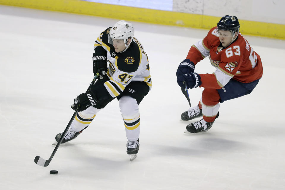 Boston Bruins defenseman Torey Krug (47) and Florida Panthers right wing Evgenii Dadonov (63) battle for the puck during the second period of an NHL hockey game, Thursday, March 5, 2020, in Sunrise, Fla. (AP Photo/Wilfredo Lee)