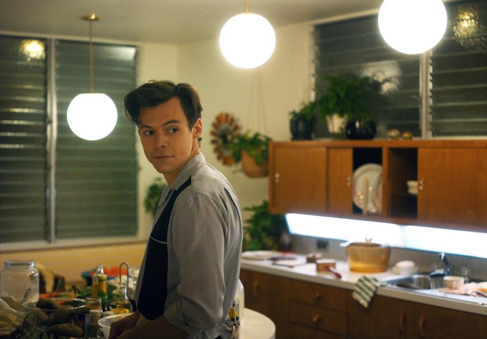 Alice's husband smiling as he sets the table for dinner