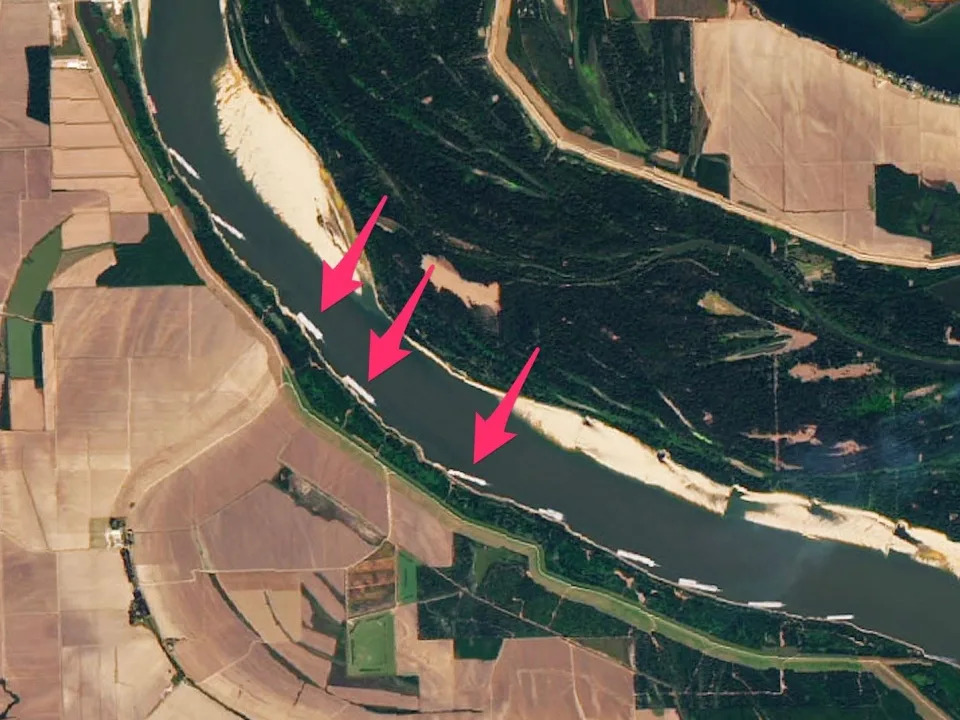 satellite image mississippi river with arrows pointing to barges lined up on shore