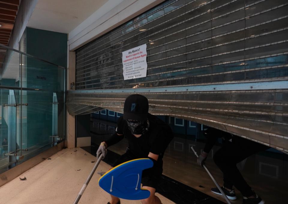 Protesters get out from a restaurant after vandalizing the same in Hong Kong, Sunday, Oct.13, 2019. The semi-autonomous Chinese city is in its fifth month of a movement that initially began in response to a now-withdrawn extradition bill that would have allowed Hong Kong residents to be tried for crimes in mainland China. The protests have since ballooned to encompass broader demands for electoral reforms and an inquiry into alleged police abuse. (AP Photo/Vincent Yu)