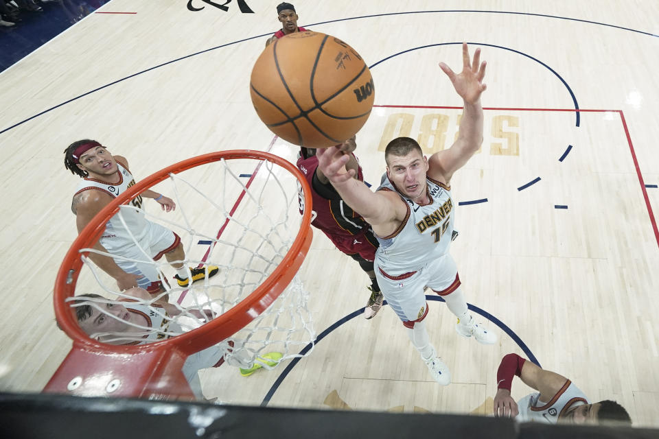 El pívot de los Nuggets de Denver Nikola Jokic y el pívot del Heat de Miami Bam Adebayo pelean por un rebote en el juego 5 de las Finales de la NBA el lunes 12 de junio del 2023. (AP Foto/Jack Dempsey, Pool)