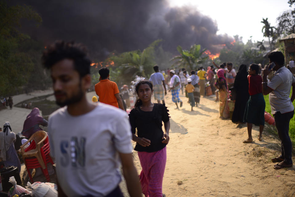 Rohingya refugees try to salvage their belongings after a major fire in their Balukhali camp at Ukhiya in Cox's Bazar district, Bangladesh, Sunday, March 5, 2023. A massive fire raced through a crammed camp of Rohingya refugees in southern Bangladesh on Sunday, leaving thousands homeless, a fire official and the United Nations said. (AP Photo/Mahmud Hossain Opu)