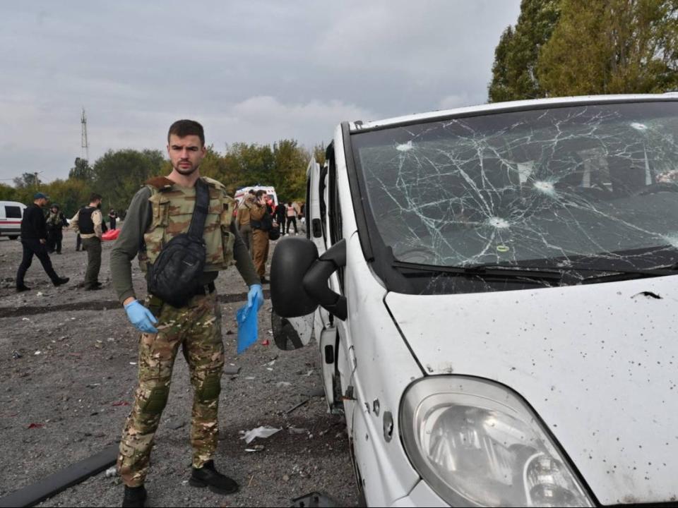 A police officer covers stands next to a van damaged by the Russian missile strike (REUTERS)