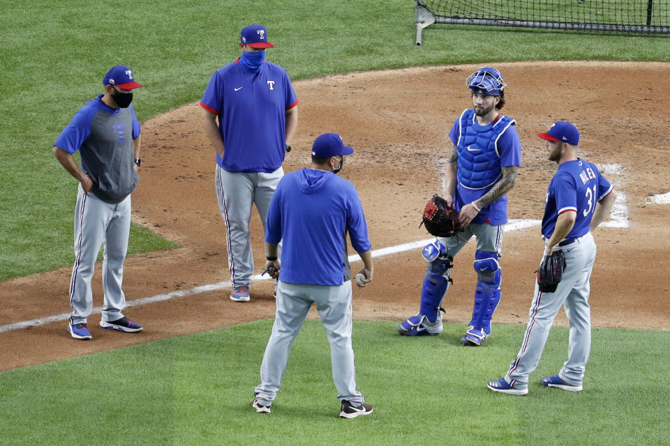 Texas Rangers manager Chris Woodward, left, bullpen coach Doug Mathis, second from left, pitching coach Julio Rangel, center front, catcher Blake Swihart, second from right, and pitcher Cody Allen, right, talk after Allen threw in a baseball practice at Globe Life Field in Arlington, Texas, Friday, July 3, 2020. (AP Photo/Tony Gutierrez)