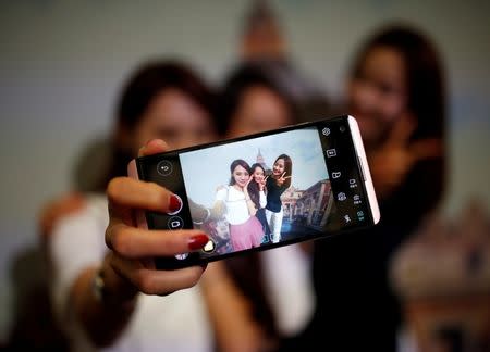 Models pose for photographs with a LG electronics' new V20 premium smartphone during its unveiling ceremony in Seoul, South Korea, September 7, 2016. REUTERS/Kim Hong-Ji