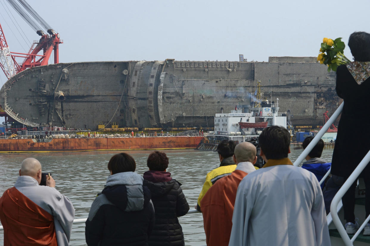 Relatives of missing victims look on as the Sewol ferry is raised: AP