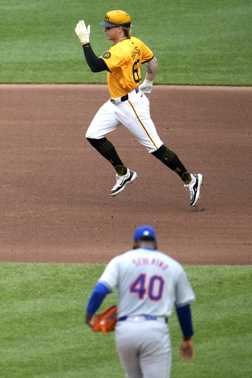 Pittsburgh Pirates' Jack Suwinski, top, rounds third after hitting a solo home run off New York Mets starting pitcher Luis Severino (40) during the fourth inning of a baseball game in Pittsburgh, Friday, July 5, 2024. (AP Photo/Gene J. Puskar)