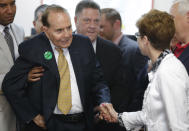 Former Sen. Bob Dole, R-Kan., second from left, greets former Mission Mayor Laura McConwell, right, at Johnson County Republican Headquarters in Overland Park, Kan., Monday, April 21, 2014. (AP Photo/Orlin Wagner)