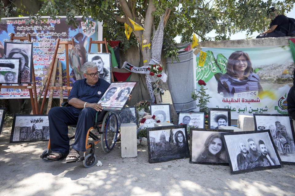 Palestinian journalist Ali Al Samoudi visits a makeshift shrine at the site where veteran Palestinian-American Al Jazeera journalist Shireen Abu Akleh was shot and killed while covering an Israeli raid, in the West Bank city of Jenin, May 19, 2022. Almost two weeks after the death of Abu Akleh, a reconstruction by The Associated Press lends support to assertions from both Palestinian authorities and her colleagues that the bullet that cut her down came from an Israeli gun. (AP Photo/Majdi Mohammed)