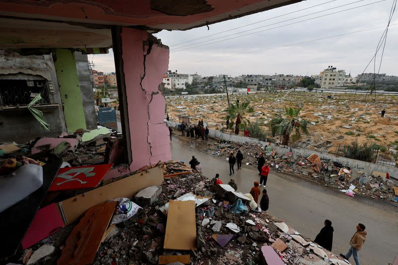 Palestinos inspeccionan el lugar de un ataque israelí contra una casa en Ráfah